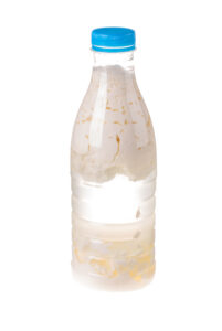 Sour milk in a plastic bottle. Isolated on the white background.
