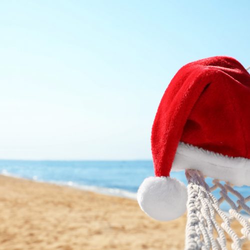 Rope hammock with Santa's hat on beach, closeup. Christmas vacation